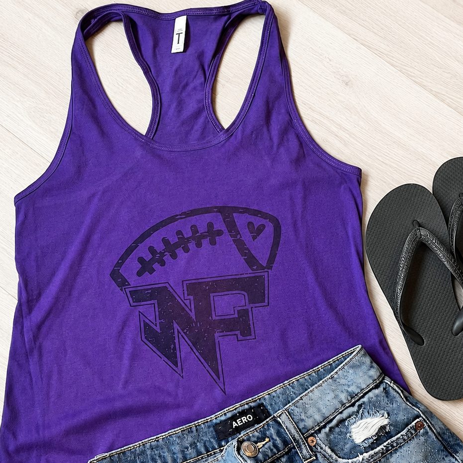 A purple racerback tank top with a dark purple football graphic and 'WN' logo, styled in a flat lay with distressed denim shorts and black flip-flops on a light wood floor.