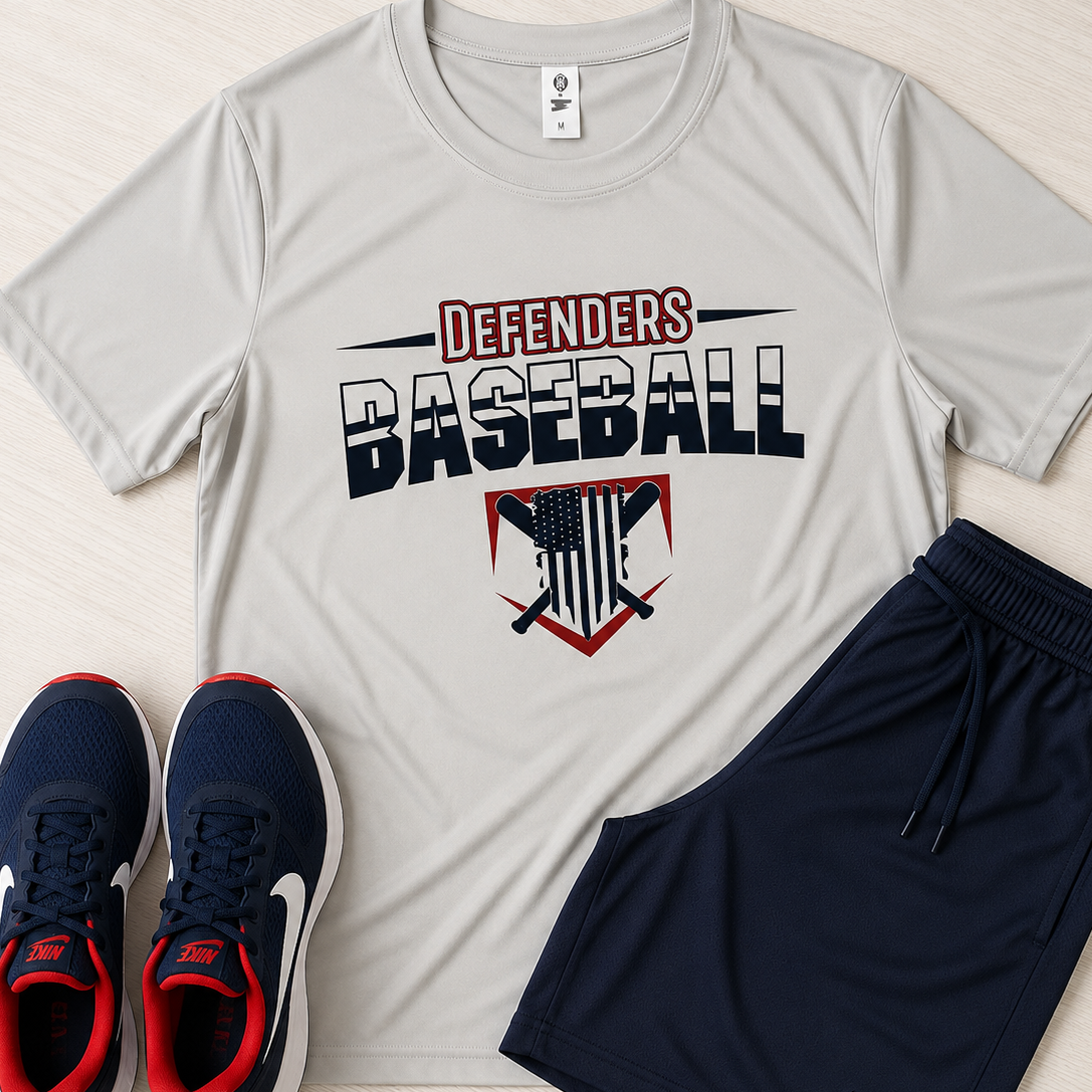 A flat-lay of a light gray athletic t-shirt with a 'Defenders Baseball' graphic, paired with navy blue Nike shorts and navy blue sneakers with red accents, on a light wood background.