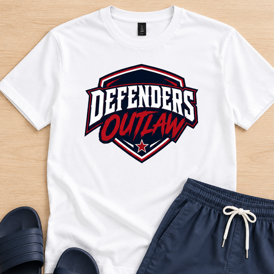 A flat-lay of a white graphic t-shirt with a red and navy 'Defenders Outlaw' logo, paired with navy blue drawstring shorts and navy slide sandals on a light wood background.