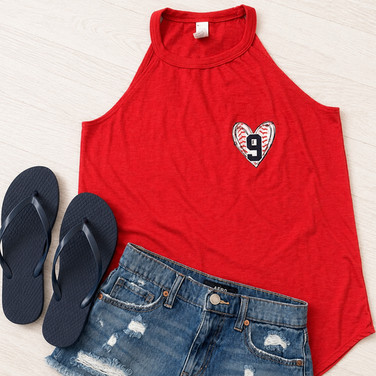 A red sleeveless crop top with a distressed heart graphic containing the number 9, styled in a flat lay with blue denim shorts and black flip-flops on a light wood background.