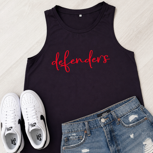 A black sleeveless tank top with the word 'defenders' printed in red script across the chest, styled in a flat lay with white sneakers and distressed blue denim shorts on a light wood background.