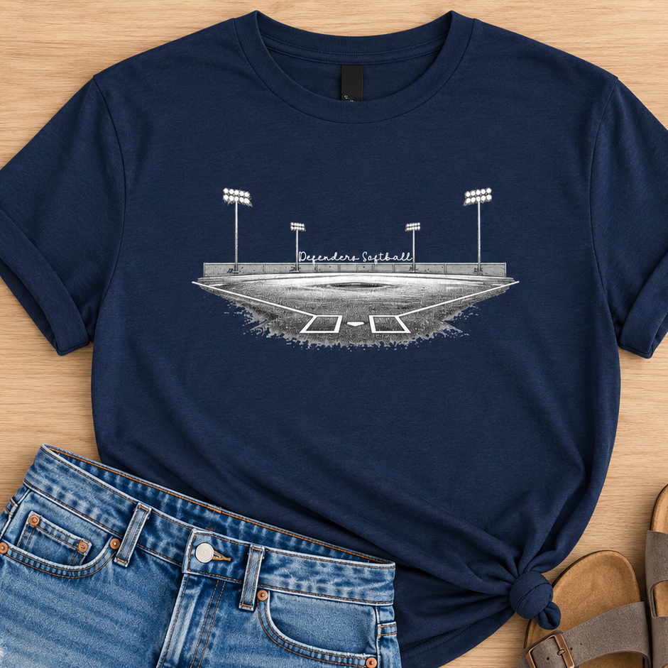 A navy blue graphic t-shirt featuring a white and gray illustration of a football stadium with the text 'Buckeye Football', styled in a flat lay with distressed denim shorts and brown slide sandals on a light wood background.