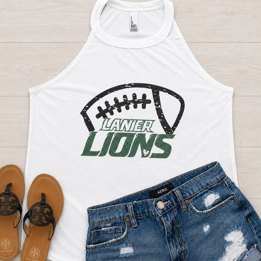 White sleeveless tank top with a distressed black football graphic and green 'LANIER LIONS' text, styled flat-lay on a light wood background with blue denim shorts and brown sandals.