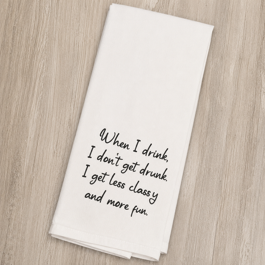 A white kitchen towel with black cursive text that reads 'When I drink, I don't get drunk. I get less classy and more fun.