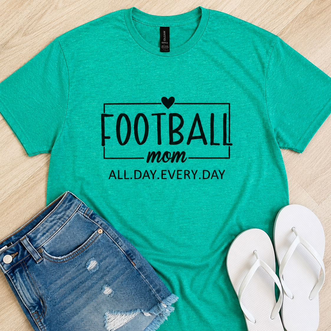 A heather teal t-shirt with a black graphic reading 'FOOTBALL mom ALL.DAY.