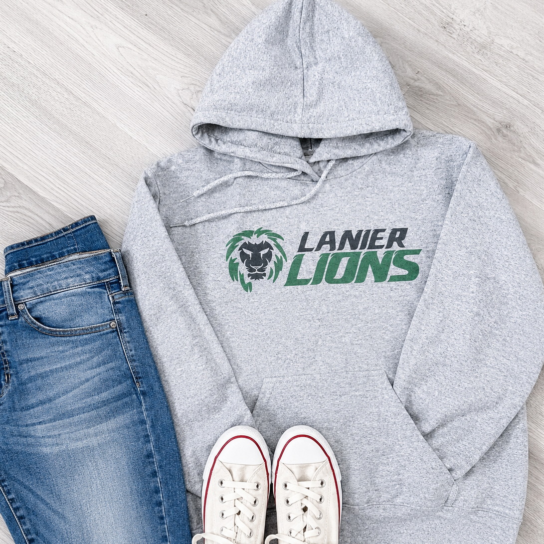 A styled flat-lay of a heather gray hoodie with a 'LANIER LIONS' graphic, paired with blue jeans and white sneakers on a light wood floor.