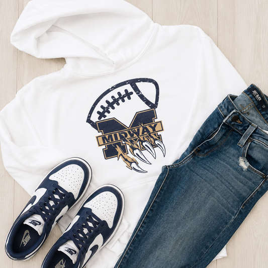 A styled flat-lay outfit on a light wood floor featuring a white hoodie with a navy and gold Michigan Wolverines football graphic, paired with blue jeans and navy and white sneakers.